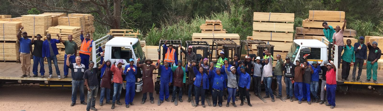 The whole Heart Eco team in the yard, with loaded trucks behind